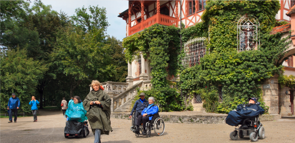 Rollstuhlfahrer vor einem romatischen Haus am Ammersee