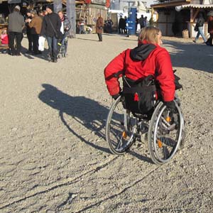 Rollifahrer auf dem sandigen Weg